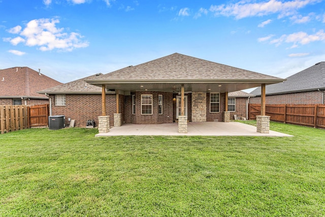 rear view of property with brick siding, roof with shingles, central AC unit, and a fenced backyard