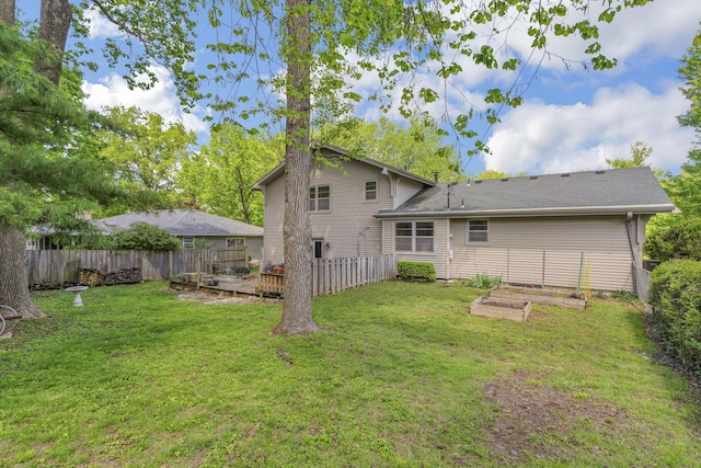 2941 S Versailles Ave, Springfield, MO 65804 - rear view of house featuring a yard, a vegetable garden, a deck, and fence