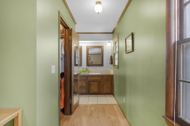 2941 S Versailles Ave, Springfield, MO 65804 - hallway with a sink, crown molding, baseboards, and light wood-type flooring