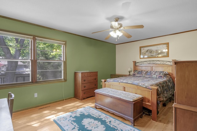 2941 S Versailles Ave, Springfield, MO 65804 - bedroom with light wood finished floors, crown molding, visible vents, baseboards, and ceiling fan