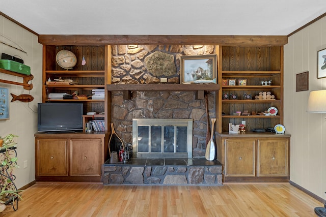 2941 S Versailles Ave, Springfield, MO 65804 - living area featuring wood walls, wood finished floors, built in shelves, a fireplace, and crown molding
