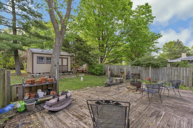 2941 S Versailles Ave, Springfield, MO 65804 - wooden terrace with an outdoor fire pit, an outdoor structure, a fenced backyard, and a storage unit