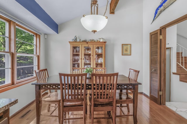 2941 S Versailles Ave, Springfield, MO 65804 - dining space with lofted ceiling, baseboards, visible vents, wood finished floors, and stairway