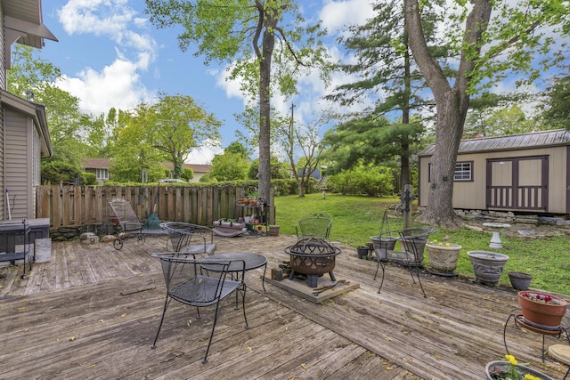 2941 S Versailles Ave, Springfield, MO 65804 - wooden deck with a fire pit, an outbuilding, fence, and a lawn