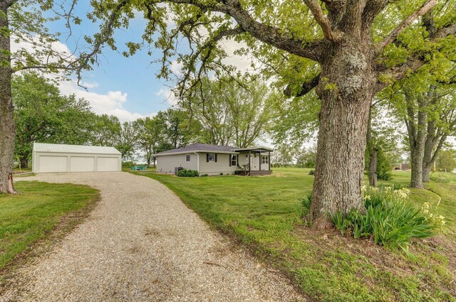 ranch-style home with a front lawn, an outdoor structure, and a detached garage