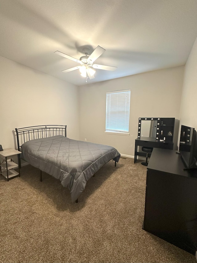 bedroom with dark colored carpet, baseboards, and ceiling fan