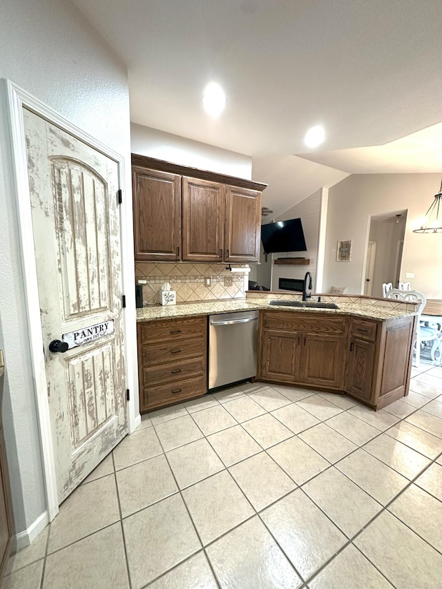 kitchen featuring backsplash, dishwasher, light tile patterned flooring, and a sink