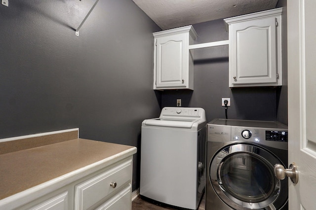 laundry room featuring cabinet space, washer and clothes dryer, and a textured ceiling