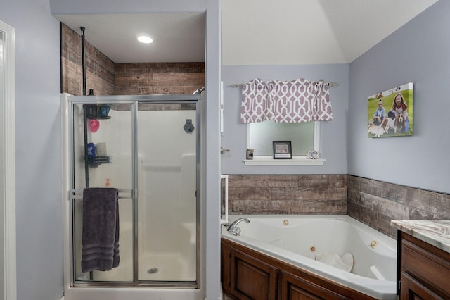 bathroom featuring a shower stall, vanity, and a whirlpool tub