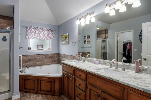 bathroom featuring double vanity, a jetted tub, a shower stall, and a sink