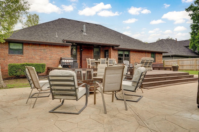 view of patio featuring outdoor dining area, fence, and grilling area