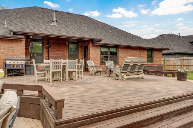 wooden deck featuring area for grilling, outdoor dining area, and fence