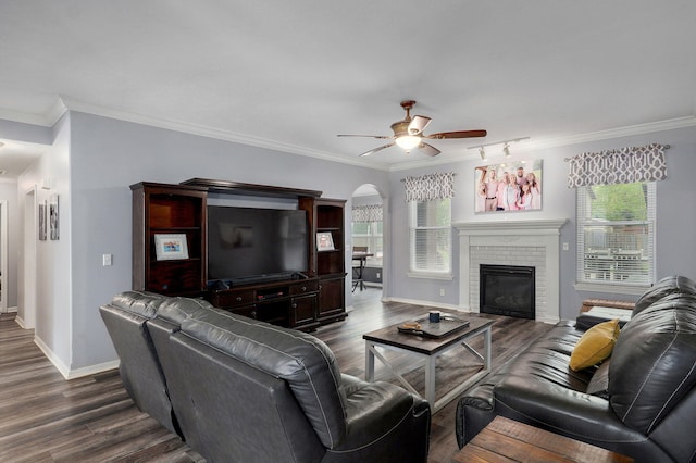 living area featuring a wealth of natural light, crown molding, and ceiling fan