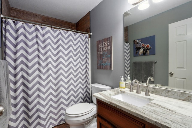 bathroom featuring curtained shower, vanity, and toilet