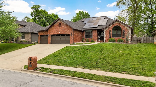 view of front of home with roof mounted solar panels, brick siding, and a front yard
