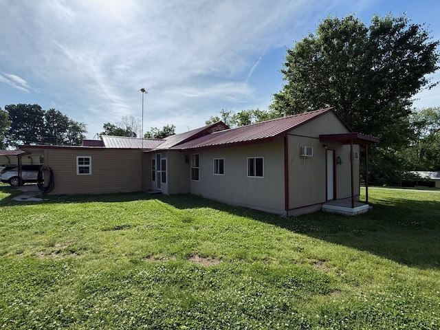 rear view of property featuring metal roof and a yard