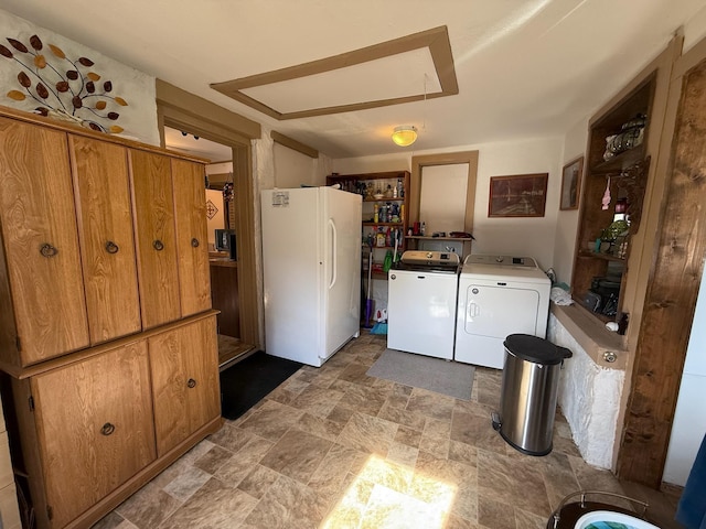 clothes washing area with laundry area, independent washer and dryer, attic access, and stone finish flooring