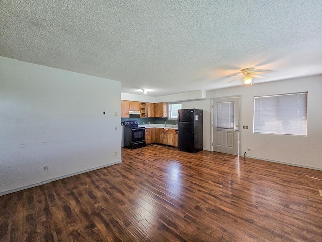 25454 Tulip Pl, Urbana, MO 65767 - kitchen with a textured ceiling, black appliances, brown cabinets, and dark wood-style flooring