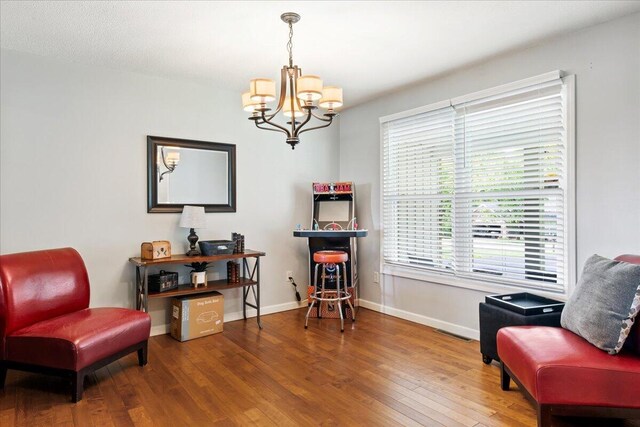 sitting room featuring wood finished floors, baseboards, and a notable chandelier