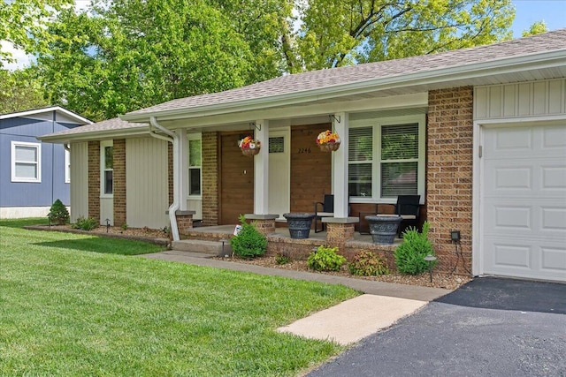 ranch-style home featuring driveway, brick siding, a front yard, a porch, and roof with shingles