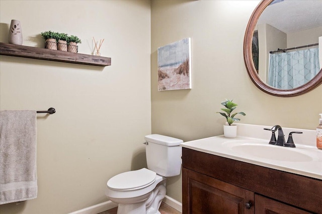 bathroom with vanity, toilet, and baseboards