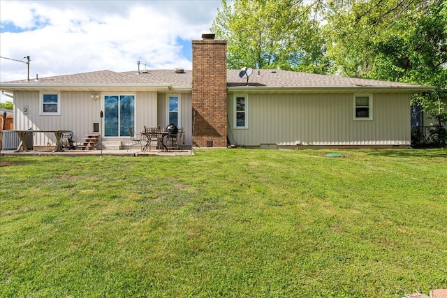 back of property featuring fence, a patio area, entry steps, a chimney, and a lawn