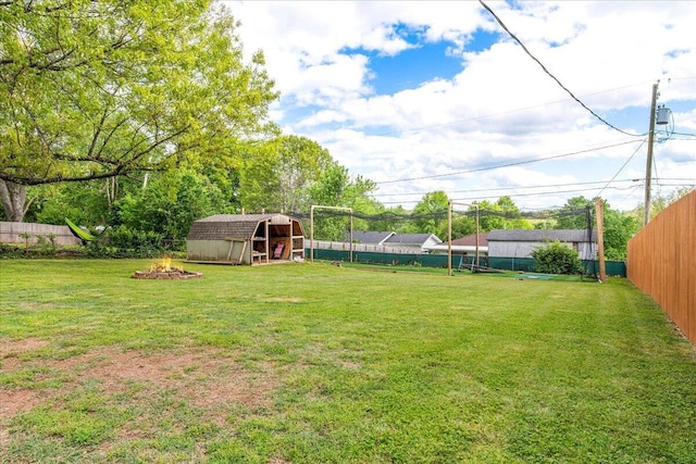 view of yard with an outdoor fire pit, an outbuilding, and fence