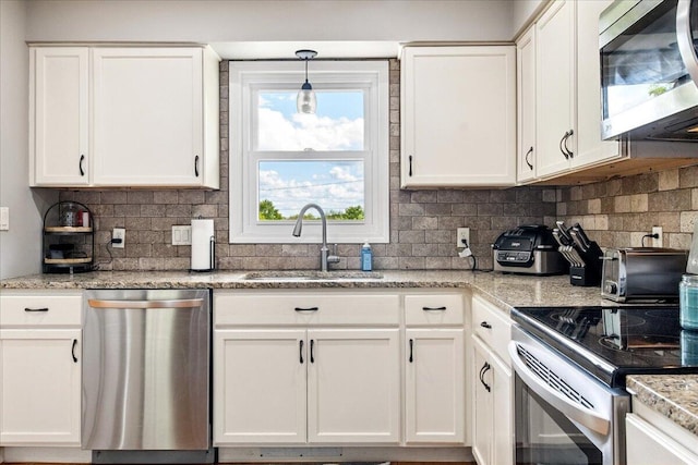 kitchen featuring a sink, stainless steel appliances, white cabinetry, and decorative backsplash