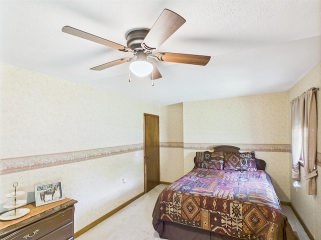 bedroom featuring a ceiling fan, light carpet, and wallpapered walls