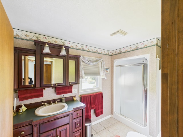 bathroom with vanity, visible vents, tile patterned floors, a shower stall, and wallpapered walls