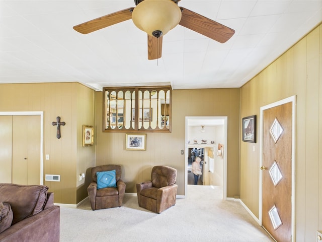 carpeted living area with visible vents and ceiling fan