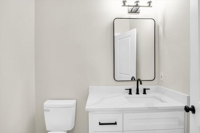 half bathroom featuring toilet and vanity