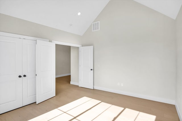 unfurnished bedroom featuring high vaulted ceiling, wood finished floors, baseboards, a closet, and recessed lighting