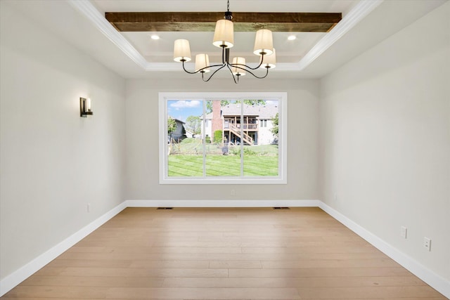 unfurnished dining area featuring a chandelier, light wood-style floors, crown molding, a tray ceiling, and baseboards
