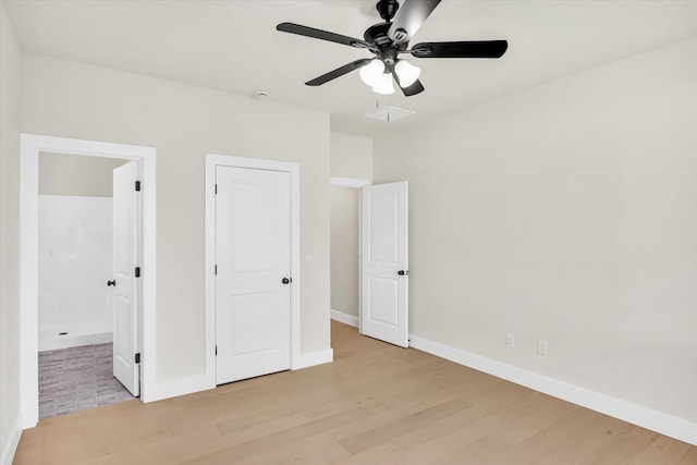 unfurnished bedroom featuring light wood finished floors, baseboards, ensuite bathroom, and ceiling fan