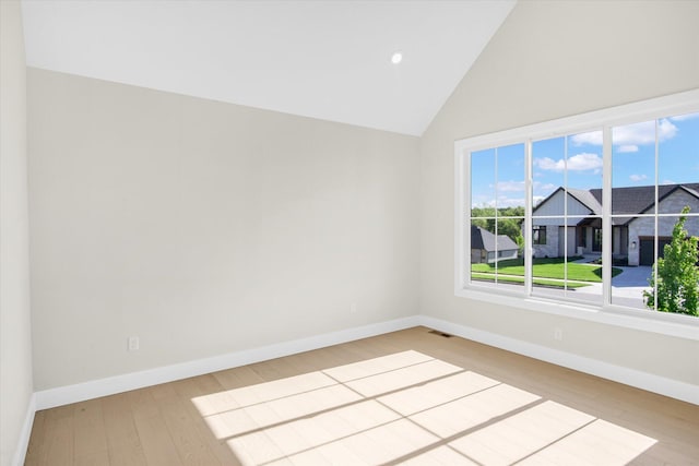 empty room featuring wood finished floors, baseboards, recessed lighting, and high vaulted ceiling