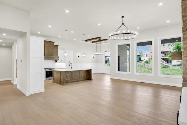 kitchen featuring stainless steel gas range oven, open floor plan, healthy amount of natural light, light countertops, and recessed lighting