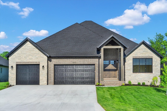 view of front facade with an attached garage, stone siding, a front yard, and concrete driveway