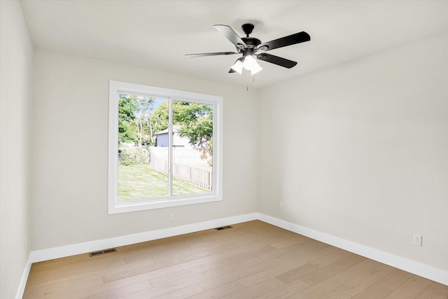 spare room with baseboards, wood finished floors, and a ceiling fan