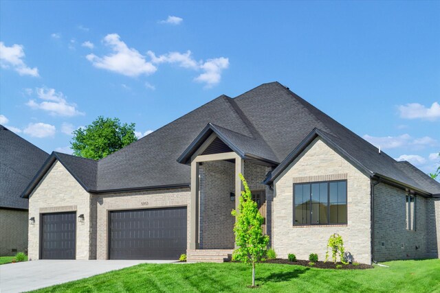 view of front facade featuring stone siding, an attached garage, and a front yard