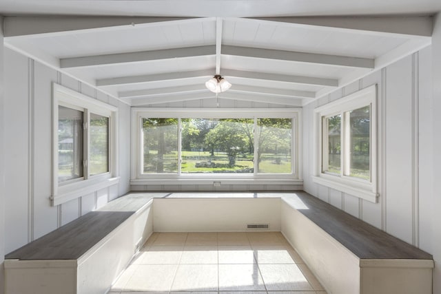 unfurnished sunroom with tile patterned flooring, a decorative wall, visible vents, and vaulted ceiling with beams