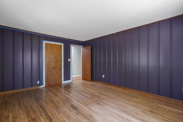 unfurnished room with a decorative wall and hardwood / wood-style floors