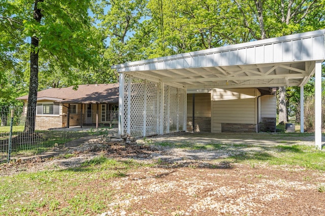 view of parking / parking lot with fence and dirt driveway