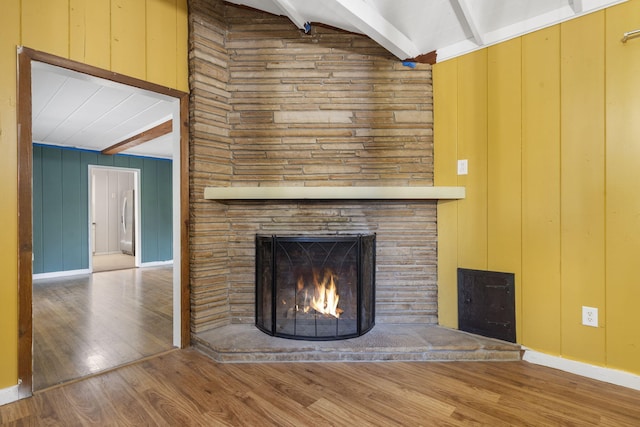 room details featuring beam ceiling, wood walls, and wood finished floors