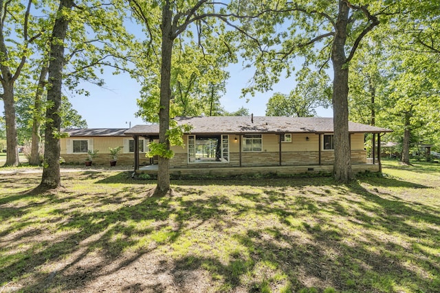 back of house featuring a yard and crawl space