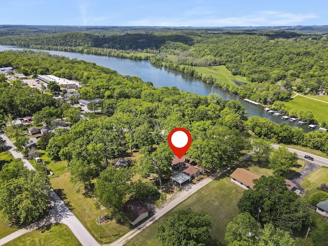 birds eye view of property with a wooded view and a water view