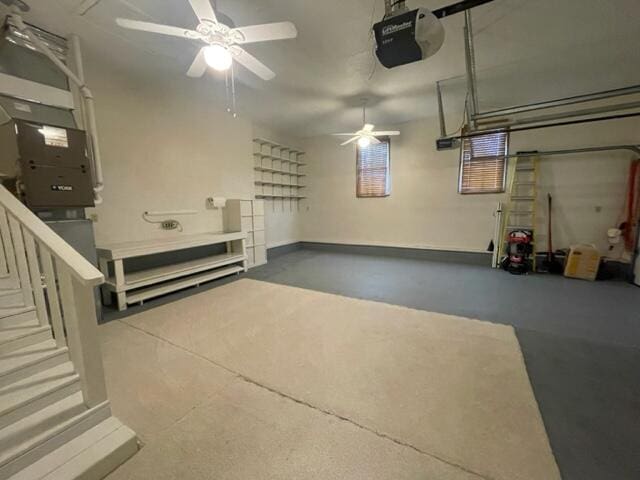 garage with baseboards, a garage door opener, and ceiling fan