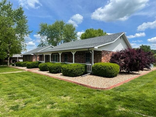view of front of home featuring a front lawn and brick siding