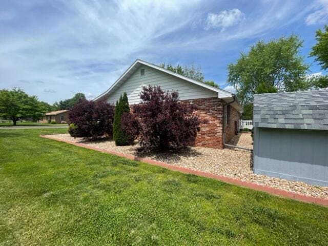 view of property exterior with a yard and brick siding