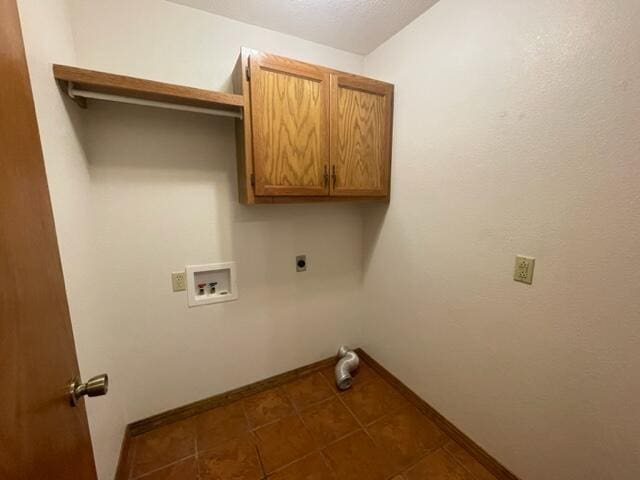 laundry area featuring baseboards, tile patterned floors, cabinet space, and washer hookup